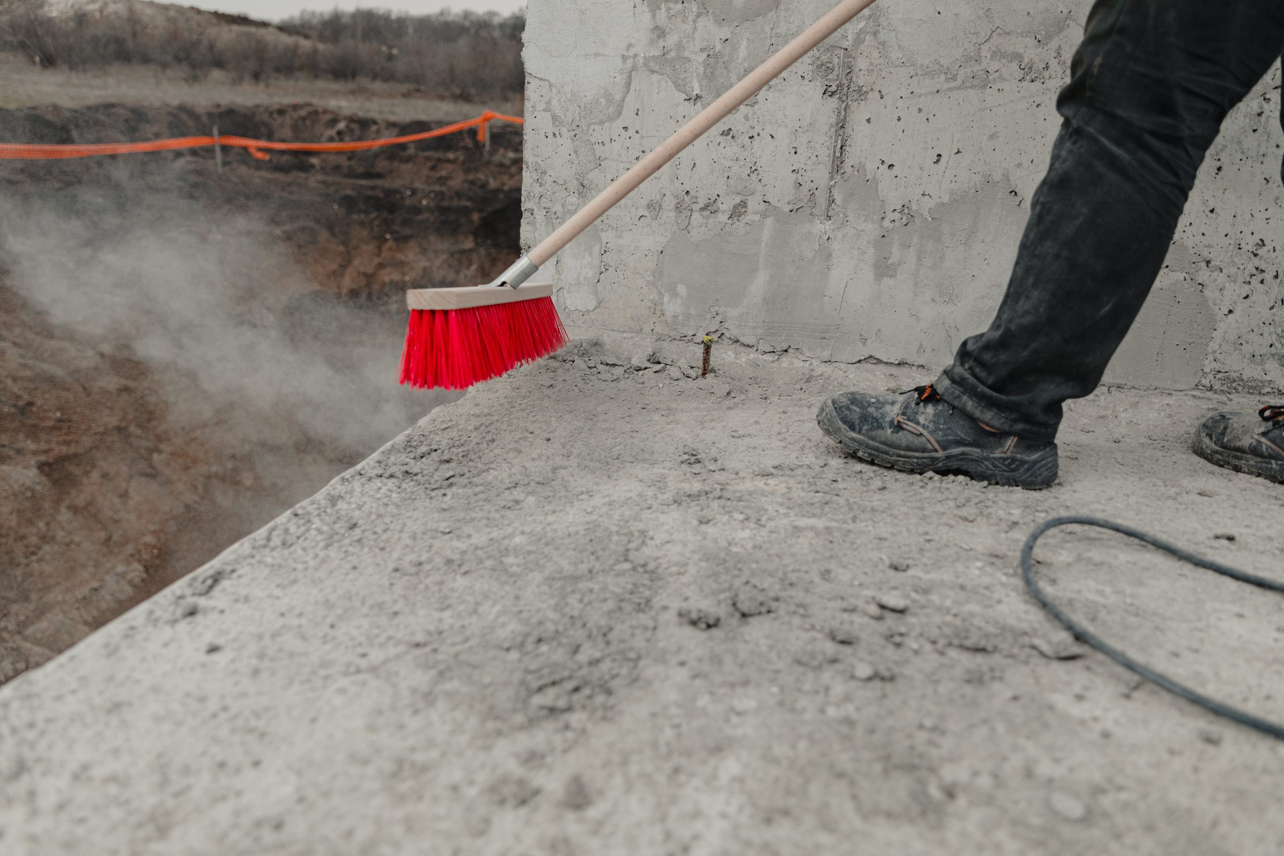 a construction worker using a broom to clean up a construction site