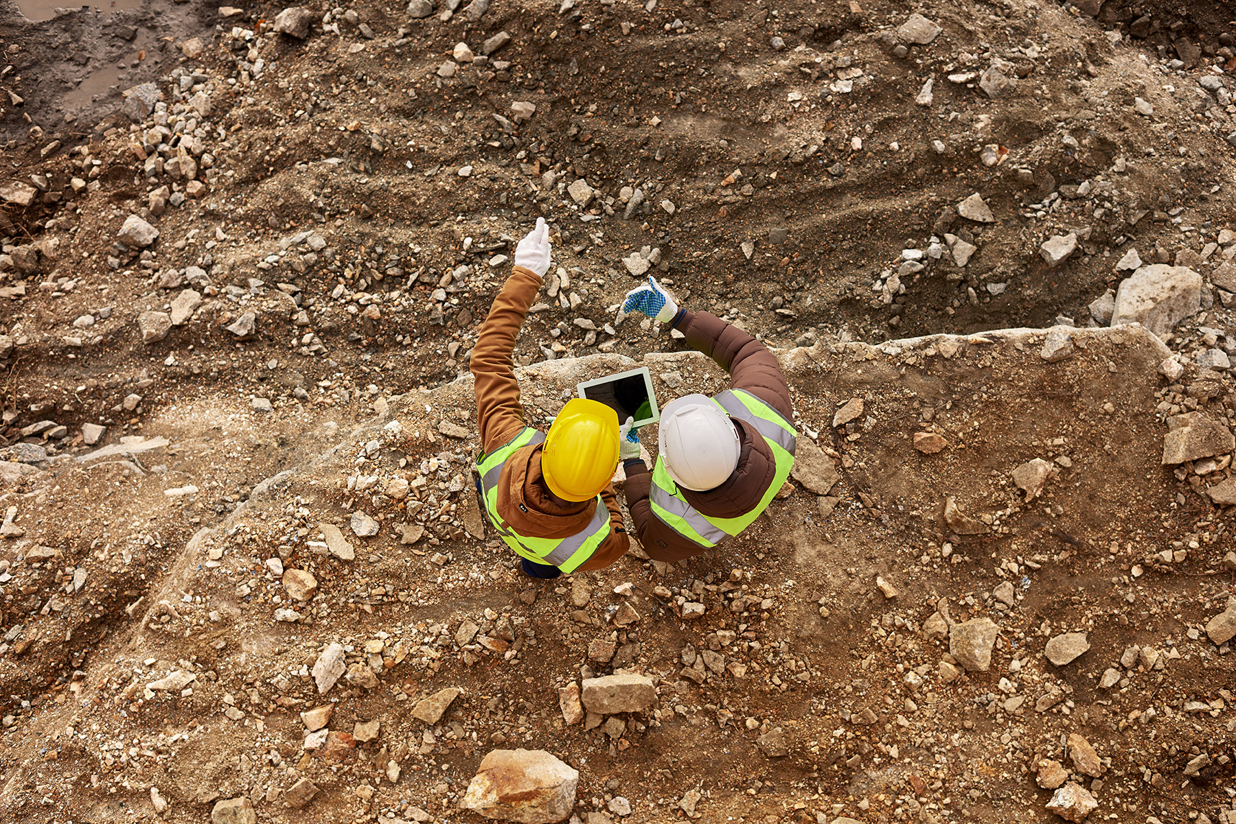 Construction project manager reviewing job cost and schedule information on a tablet at a jobsite