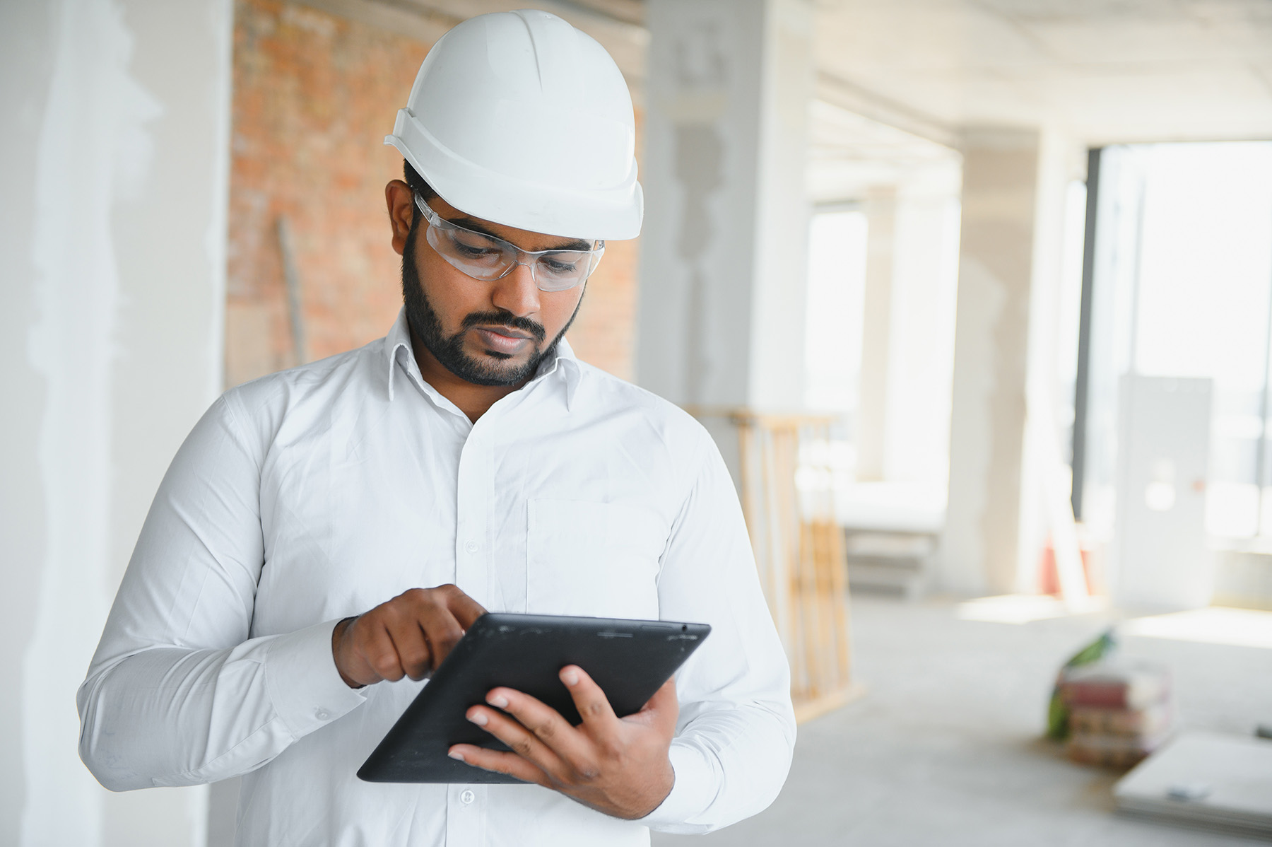 Construction project manager reviewing job costs and schedules on a laptop during a technology migration
