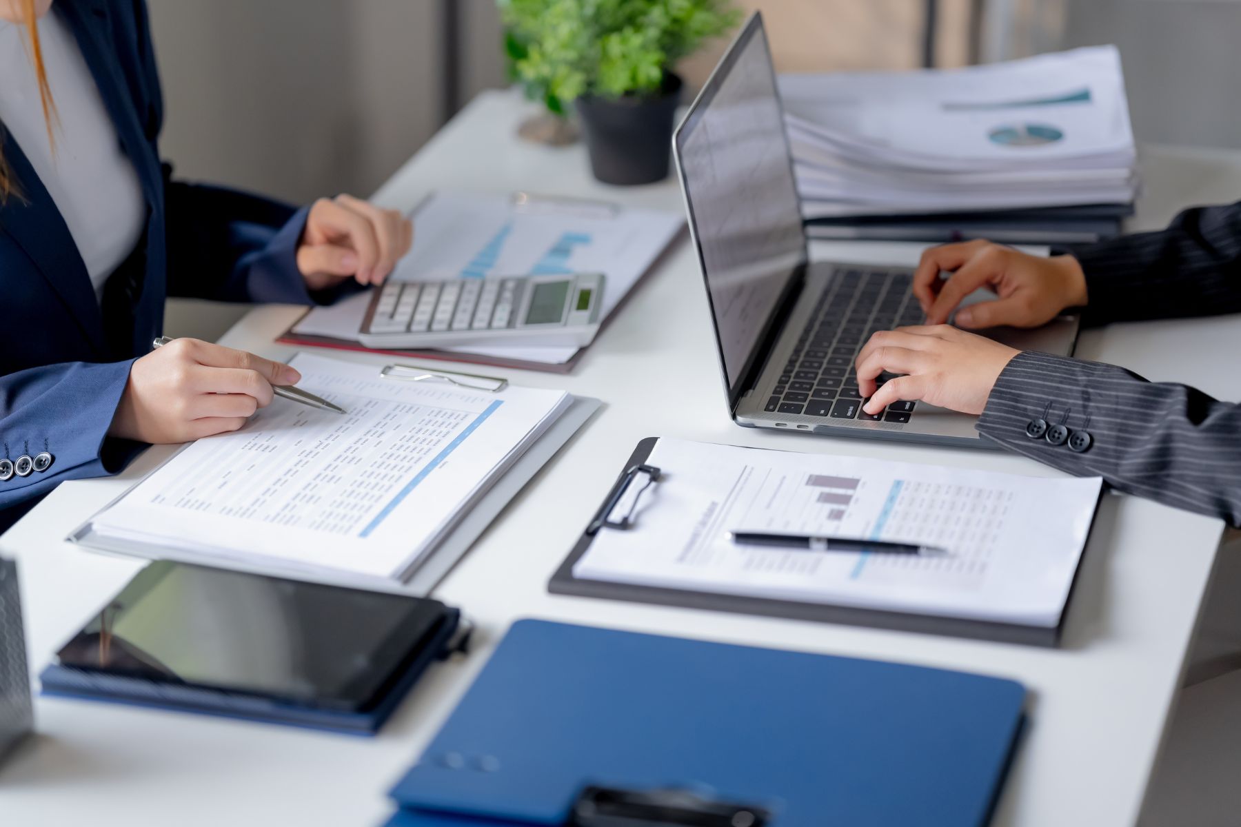 Construction office team cross-checking spreadsheets while preparing a progress billing pay application
