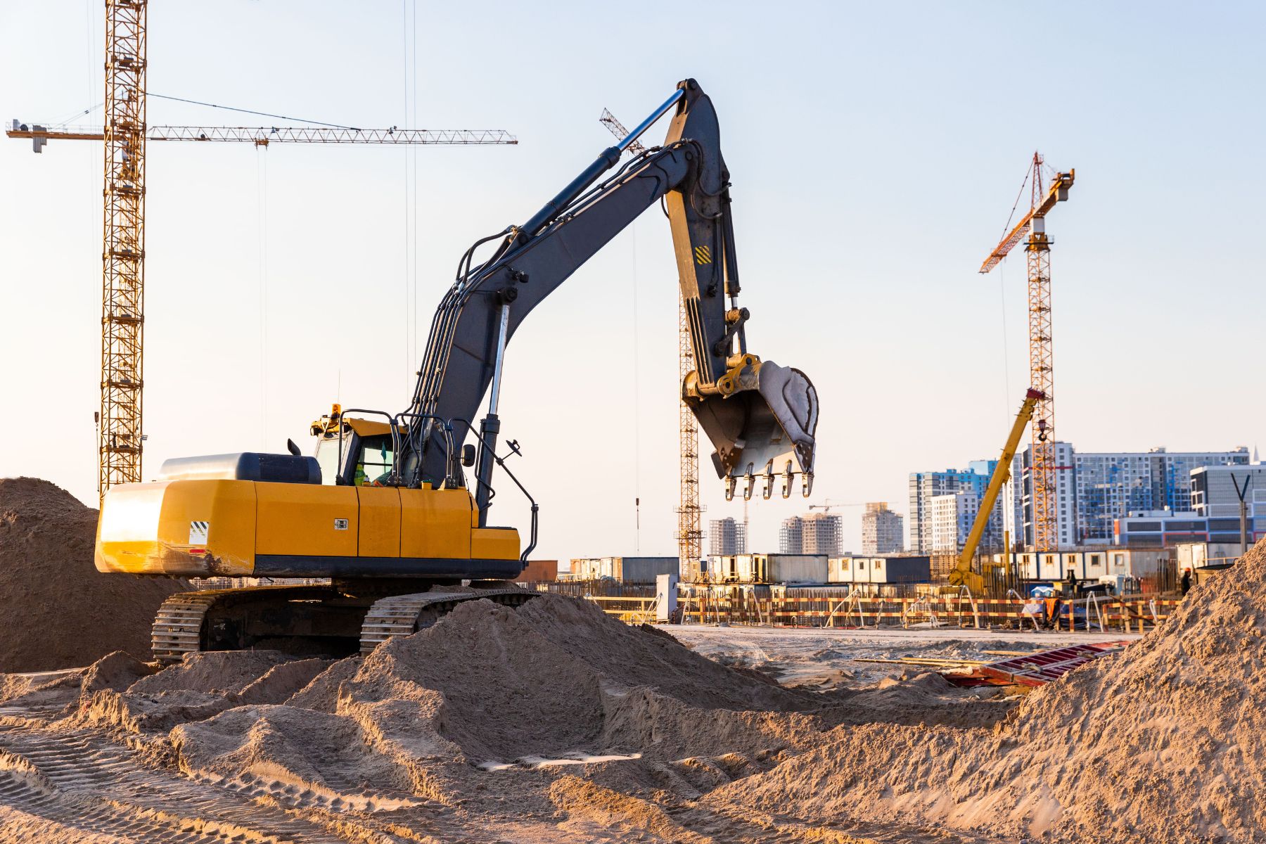 Commercial contractor reviewing an AIA progress billing pay application on a tablet at an active construction site