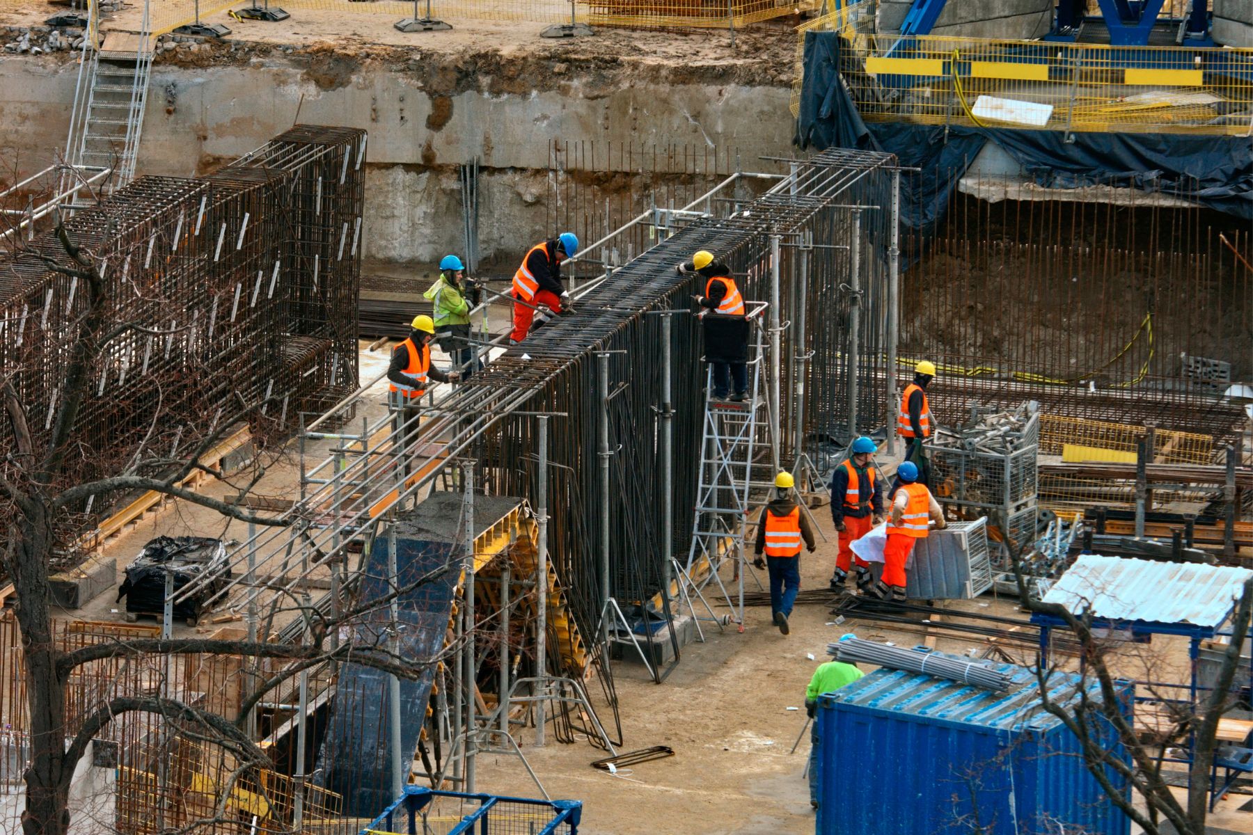 Construction project manager coordinating job costing and billing across multiple active job sites from a laptop